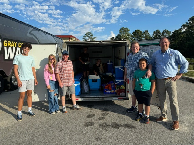 May be an image of 8 people, golf cart, road and text