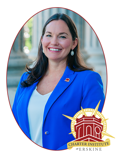 a woman in a blue jacket is smiling in front of a charter institute logo